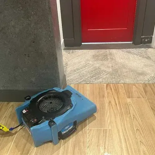 An air mover dries a wood-look tile floor near an open doorway in a typical Diamondhead drying setup