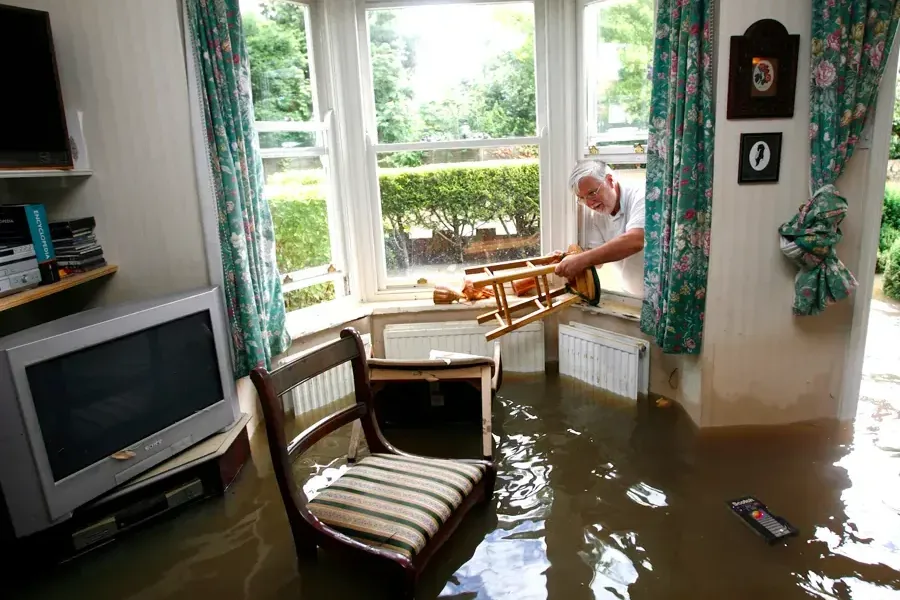 Floodwater standing in a living room up to the window sills