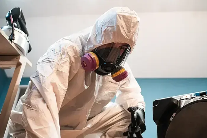 Technician in a protective suit and respirator during a contaminated water cleanup